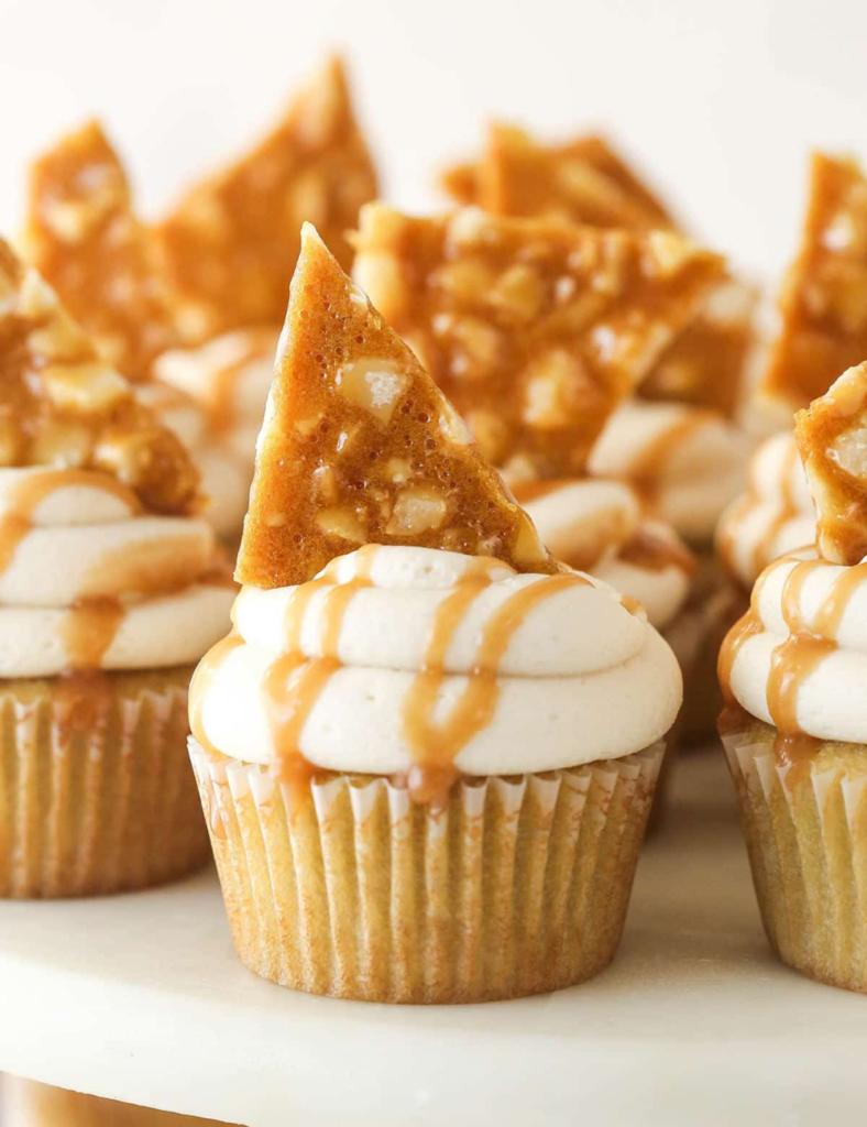 Macadamia brittle cupcakes topped with caramel buttercream and a shard of homemade brittle