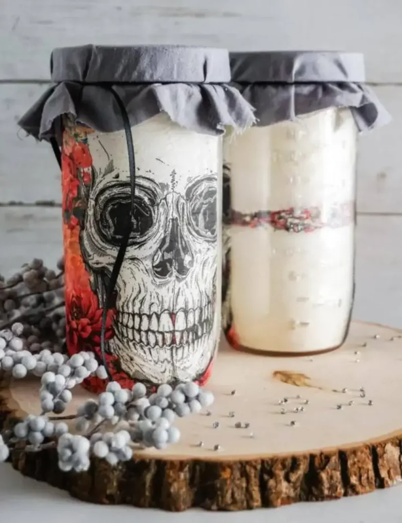 Mason jar decorated with a skull napkin design and filled with layered cookie mix ingredients