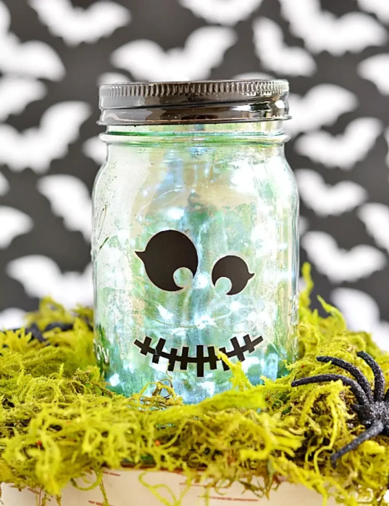Mercury glass effect mason jar lantern with a mottled mirror finish and glowing lights inside