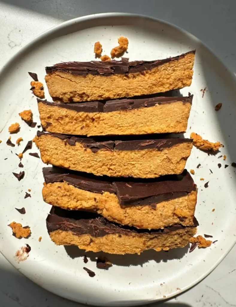 No-bake pumpkin peanut butter bars topped with a layer of dark chocolate, cut into squares