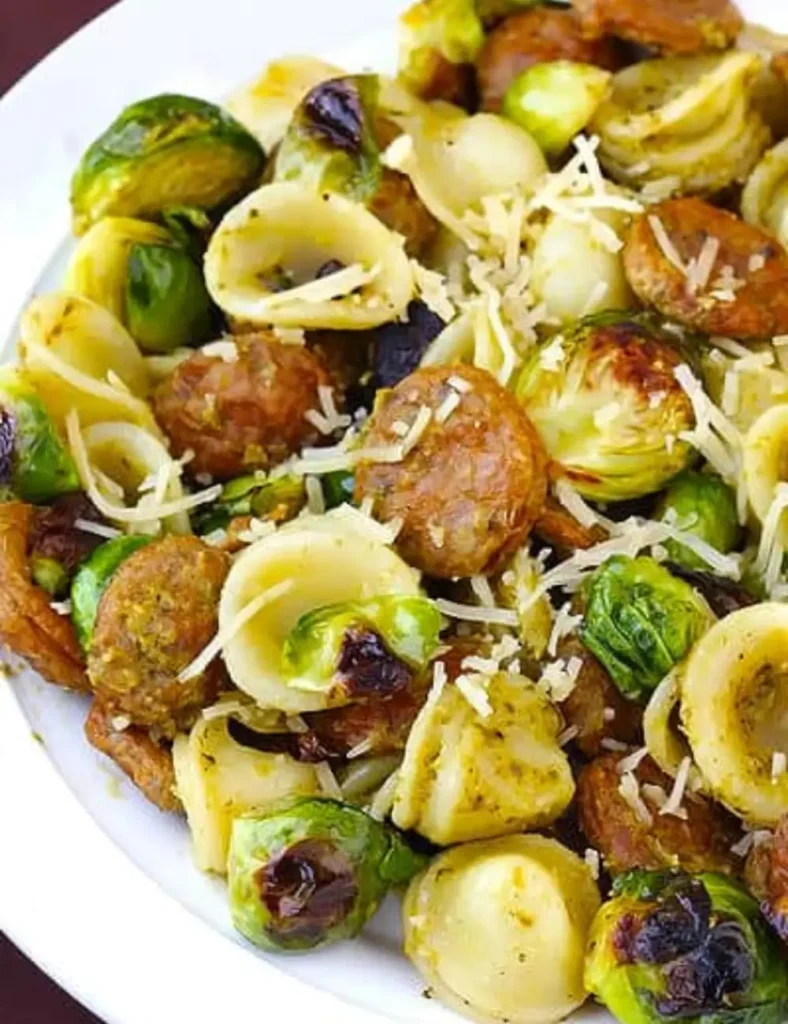 Orecchiette pasta with roasted Brussels sprouts, sliced chicken sausage and pesto topped with Parmesan