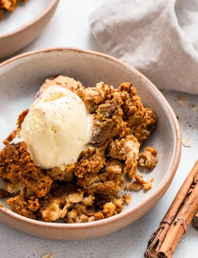 Pumpkin crisp topped with vanilla ice cream in a bowl