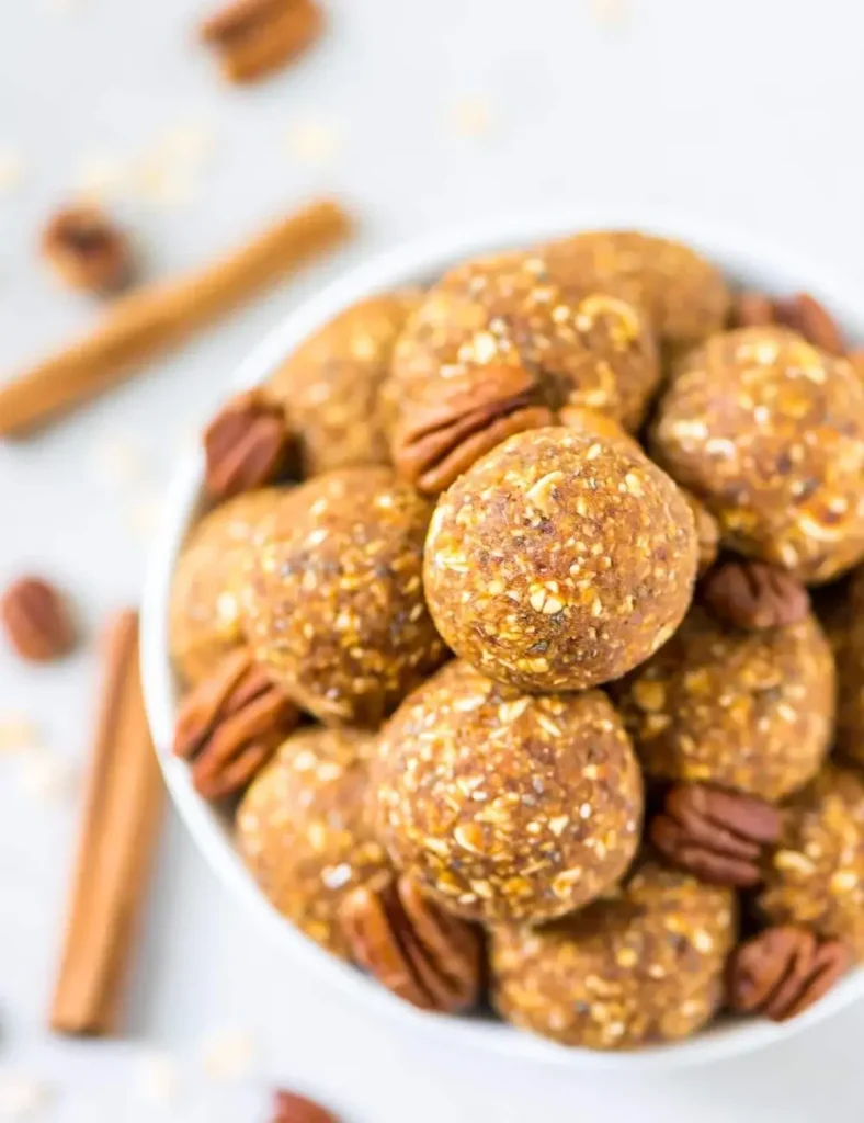 Pumpkin energy balls in a bowl garnished with pecans