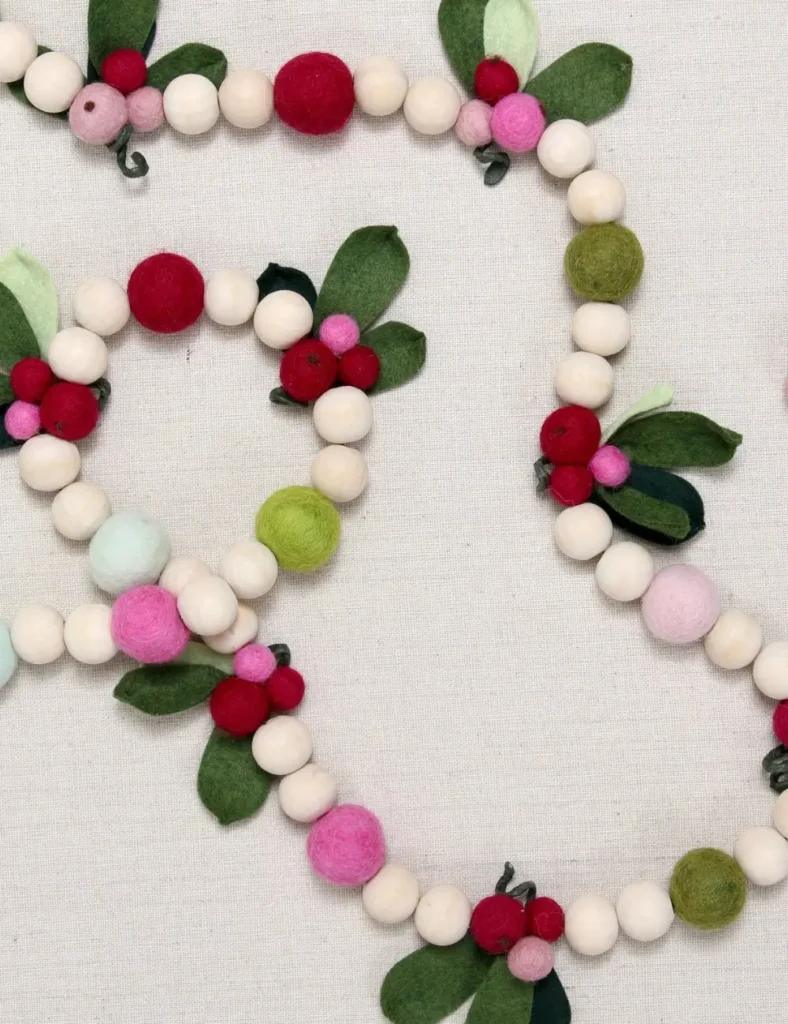 Red felt pom pom Christmas garland mixed with wooden beads and handmade felt berry sprigs