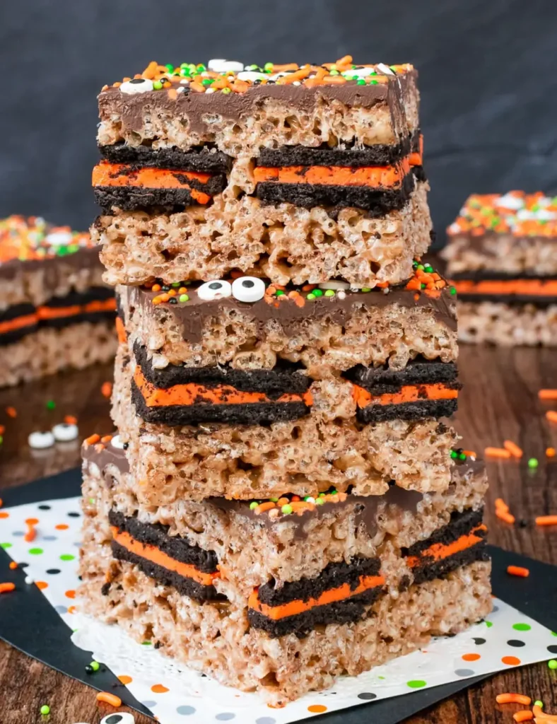 Rice Krispie treat bars with a hidden Oreo cookie layer, topped with chocolate and sprinkles