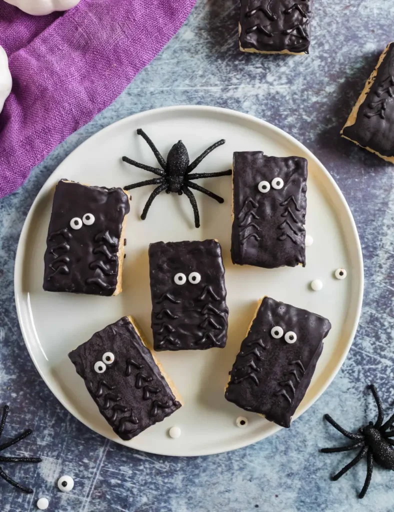 Rice Krispie treats decorated with chocolate legs and candy eyes to look like spiders