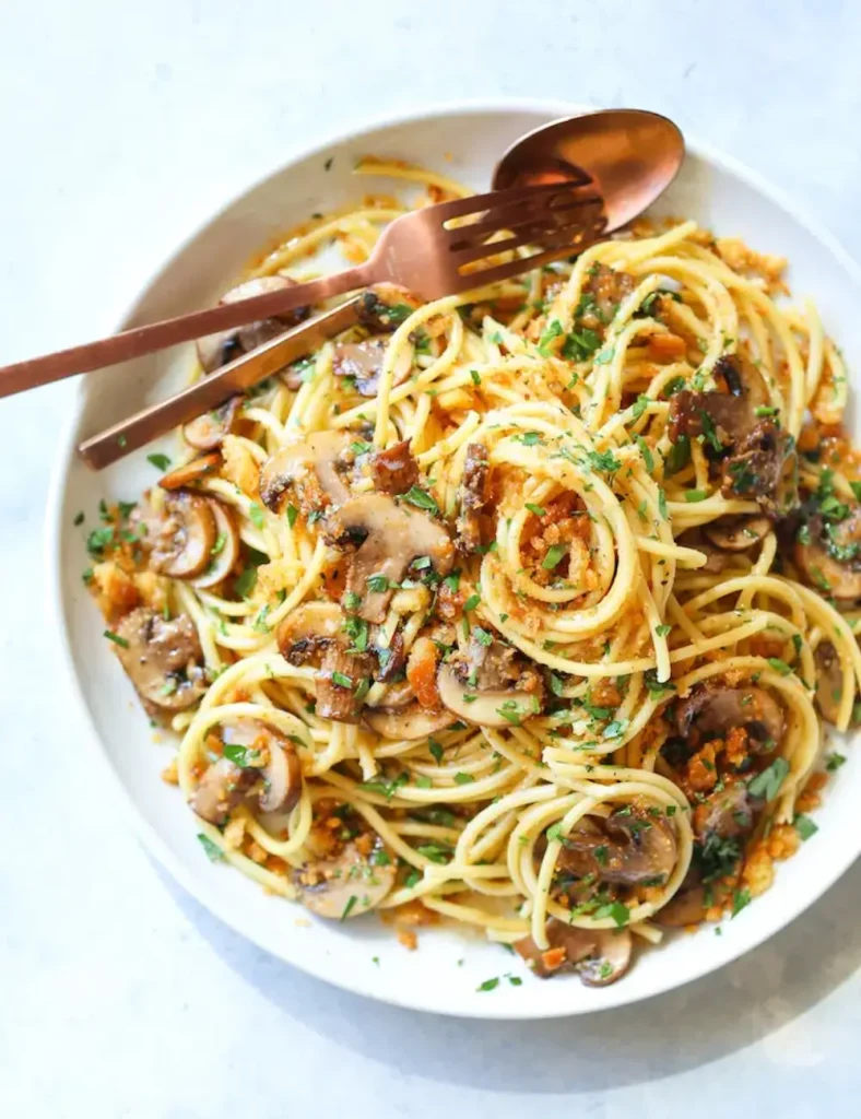 Spaghetti with brown butter mushrooms, fresh thyme and toasted breadcrumbs in a bowl