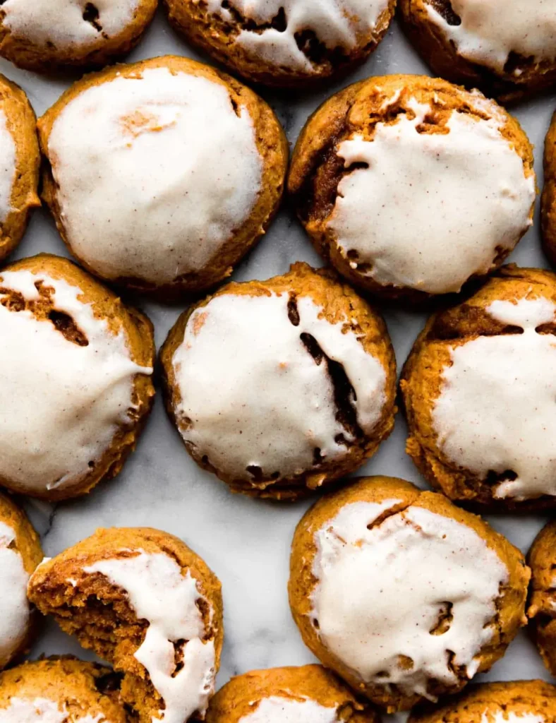 Stack of soft pumpkin cookies topped with maple cream cheese icing