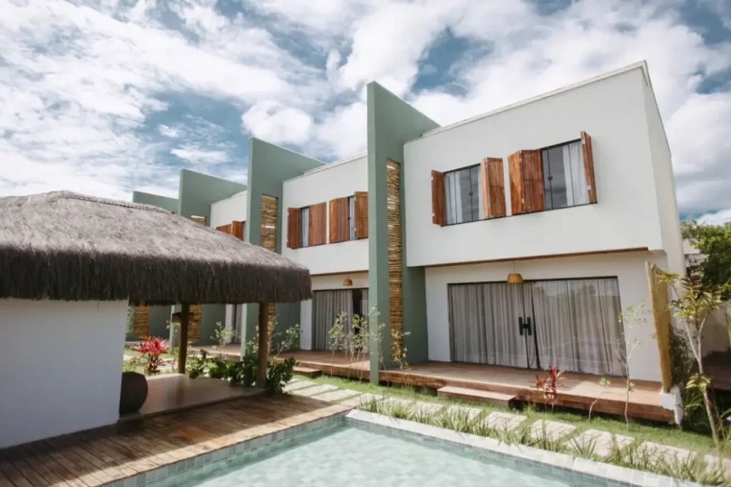 Stylish-modern-villas-with-wooden-accents-and-thatched-roofing-by-a-pool-under-a-vibrant-sky-in-Bahia-Brazil