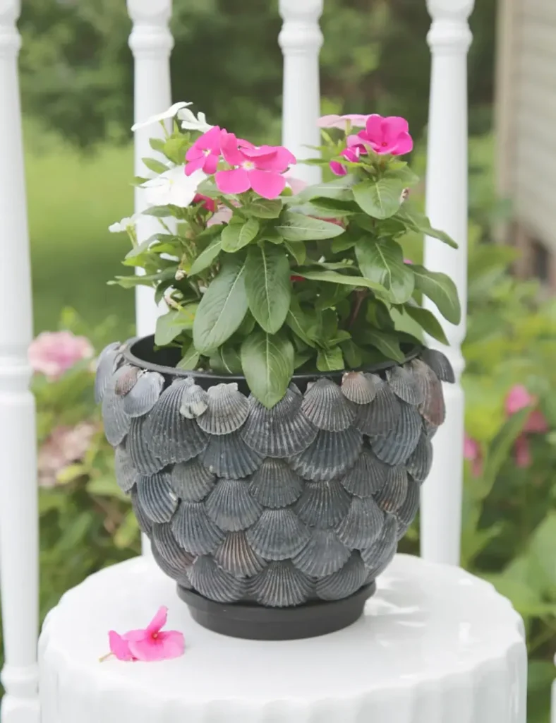 Terracotta-style planter pot fully covered in overlapping black scallop shells
