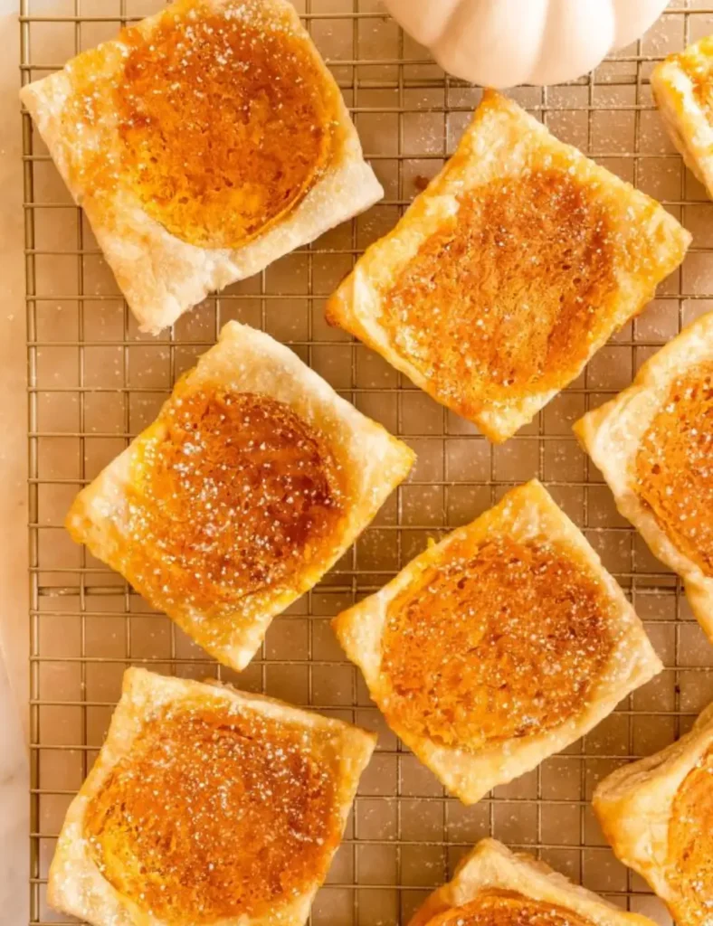 Upside down pumpkin cheesecake puff pastry squares dusted with powdered sugar
