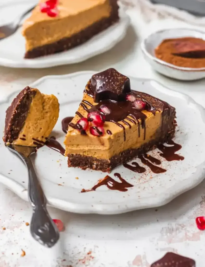 Vegan no-bake pumpkin chocolate cheesecake topped with dark chocolate and pomegranate