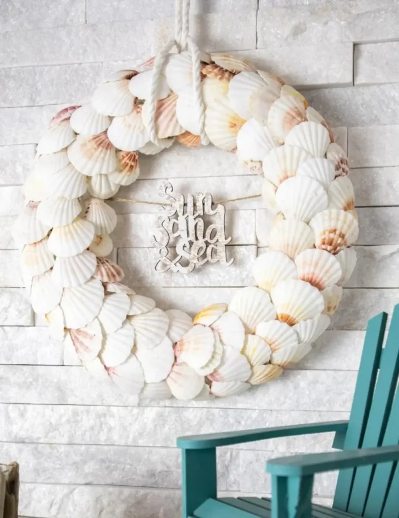 White scalloped seashell wreath with a wooden beach phrase, hanging on a door