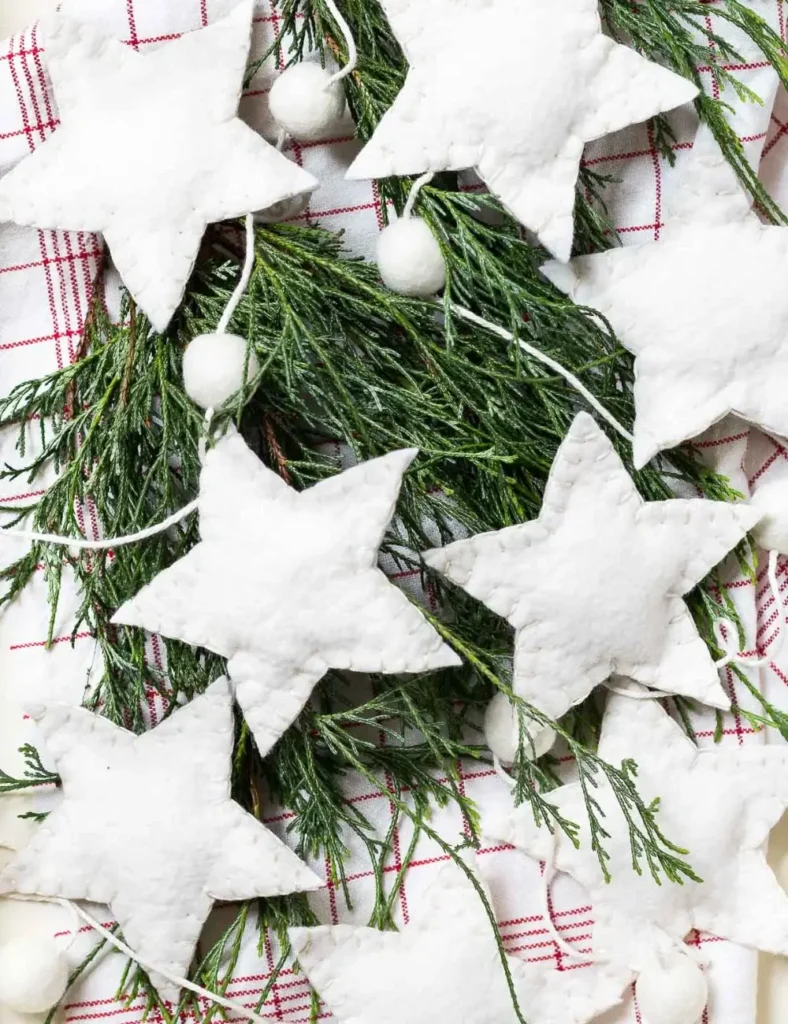 Wool felt star and ball garland draped on a small tabletop Christmas tree