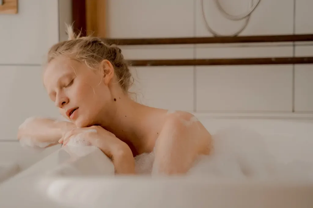 A peaceful woman enjoying a bubble bath with eyes closed, exuding serenity and calmness