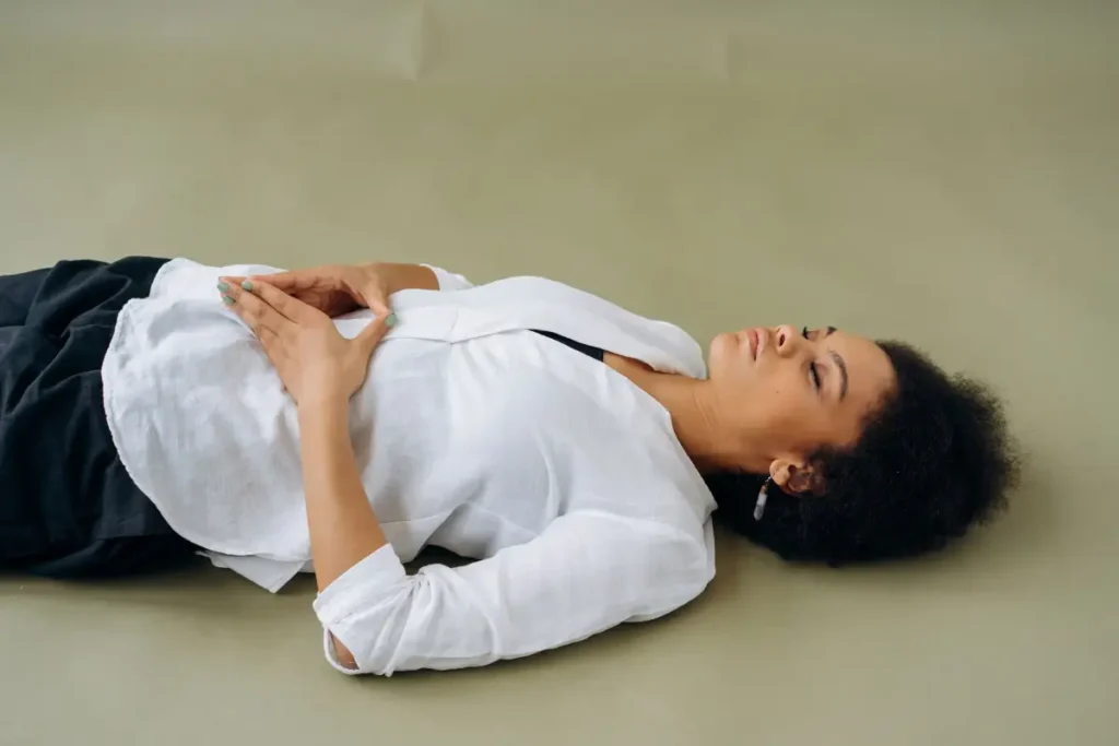 African American woman lying down with eyes closed, embodying relaxation and wellness. Perfect for wellness and mindfulness themes