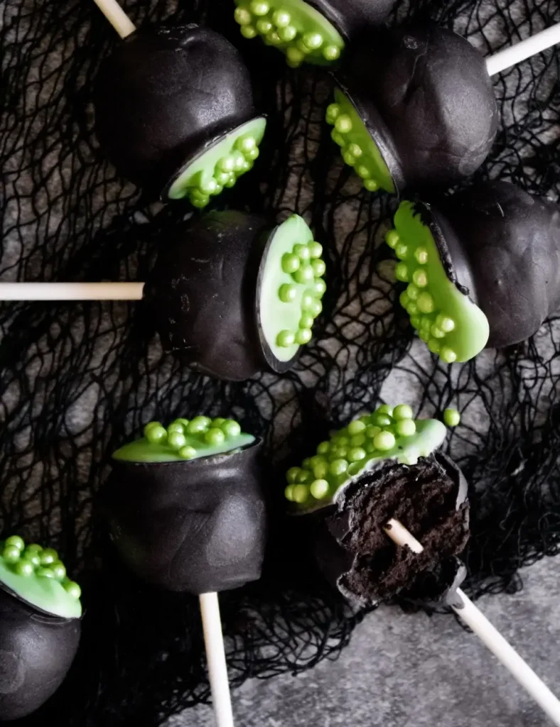 Black cauldron-shaped Halloween cake pops with green _bubbling_ tops