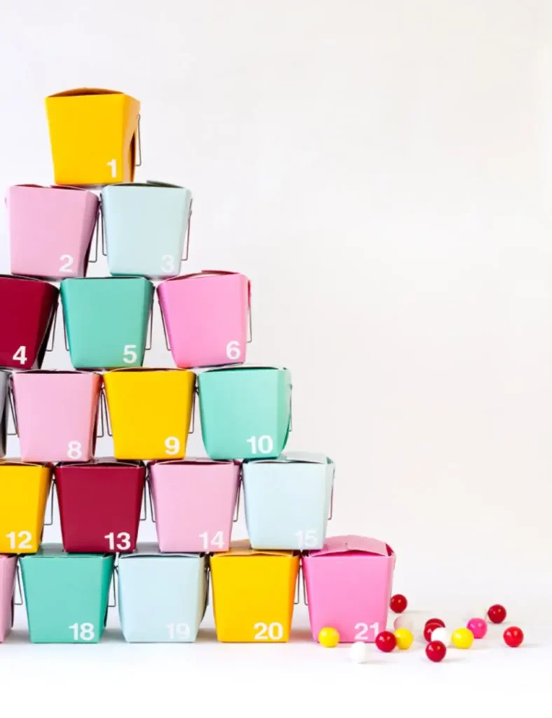 Colorful mini take-out boxes numbered and stacked as a DIY advent calendar