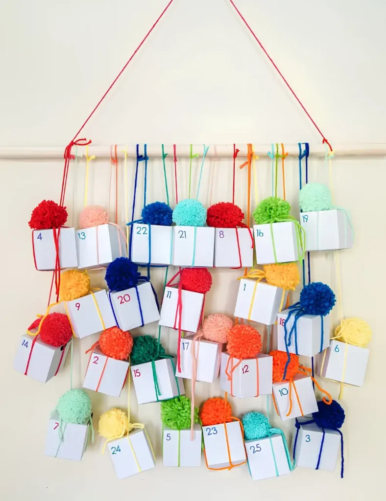 Colorful numbered advent calendar boxes hanging from yarn on a wooden dowel