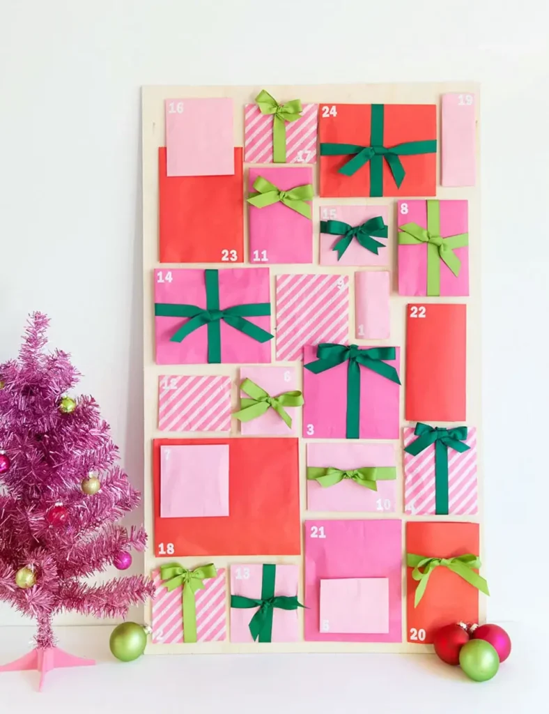 Colorful paper bags wrapped with ribbon and washi tape, arranged as a DIY advent calendar display