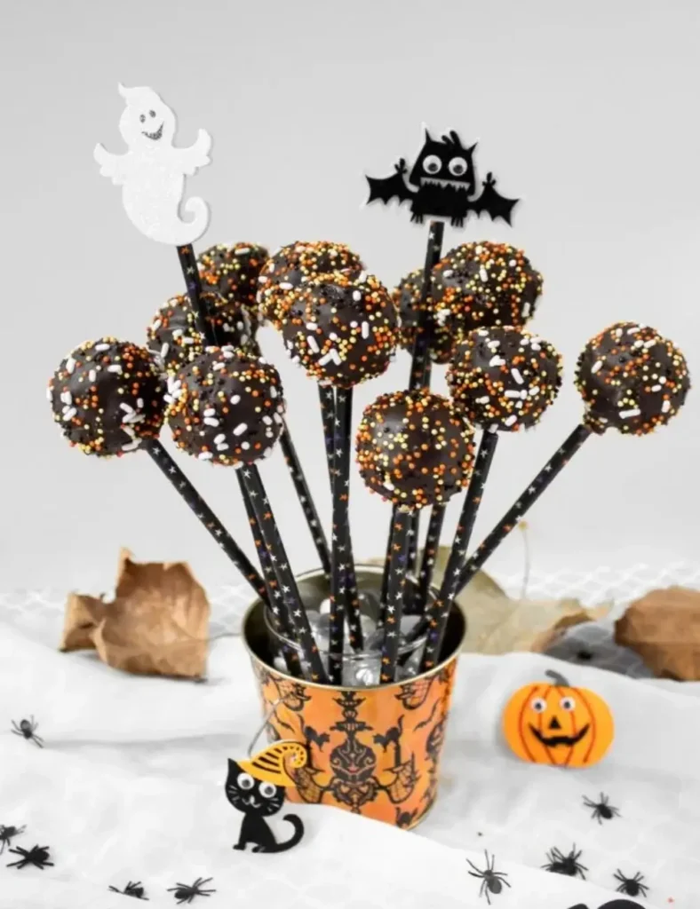 Dark chocolate cake pops covered in Halloween-themed sprinkles, arranged upright