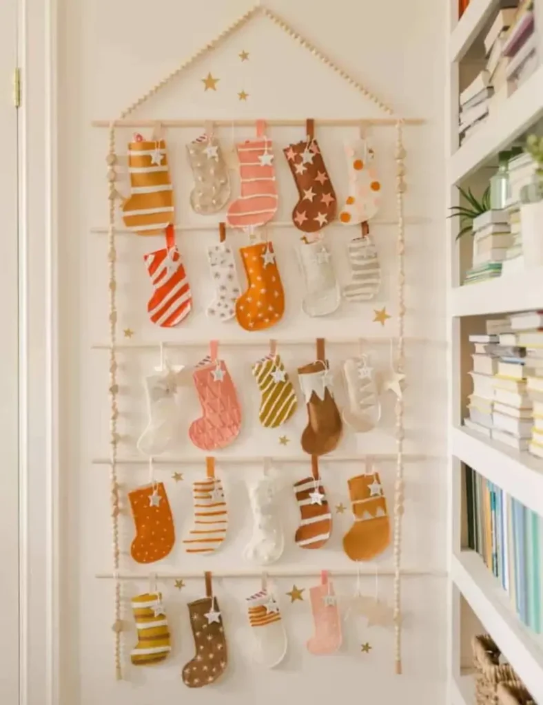 Felt stocking advent calendar hanging from a wooden dowel frame with numbered star tags