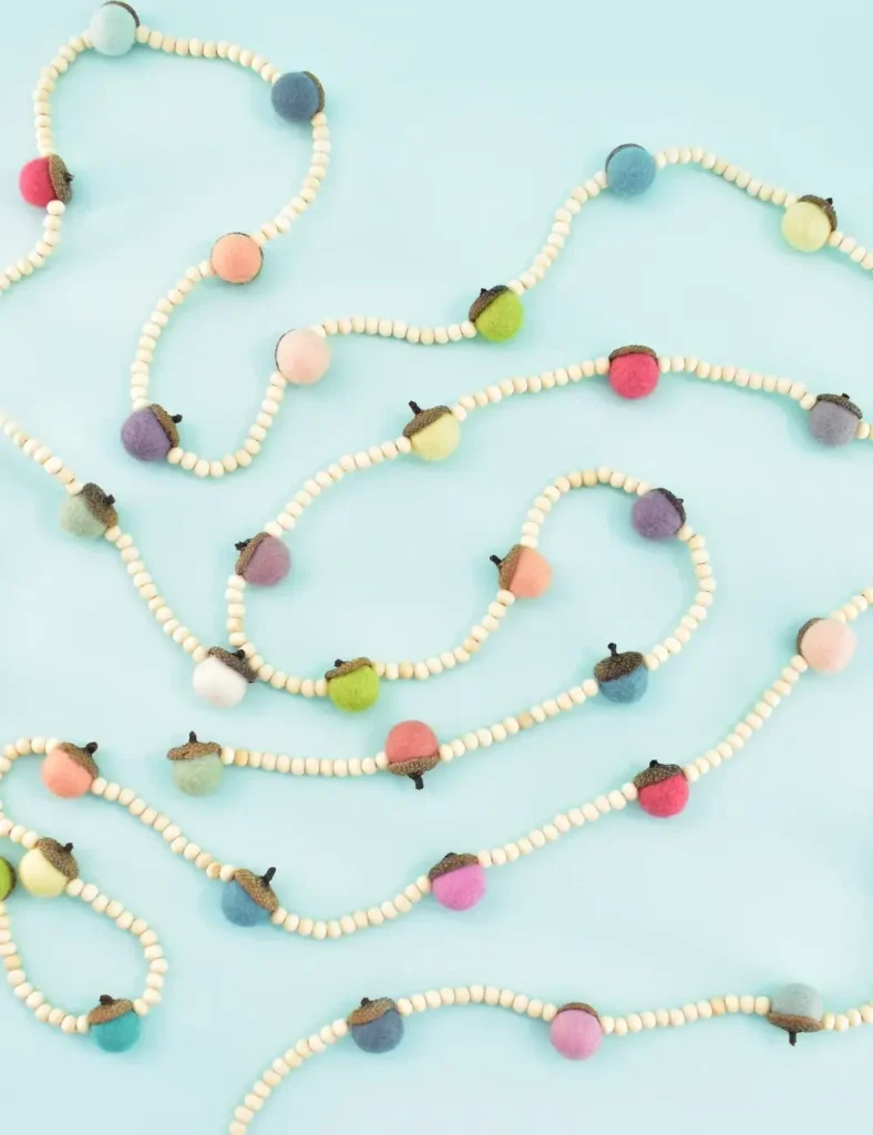 Garland of felt acorns with natural acorn caps, spaced between small wooden beads on clear line