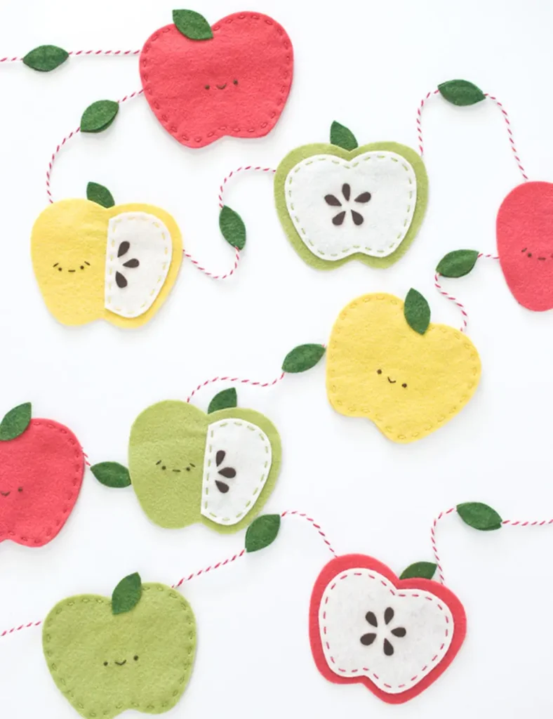 Garland of kawaii felt apples in red, yellow and green with embroidered smiley faces and felt leaf spacers