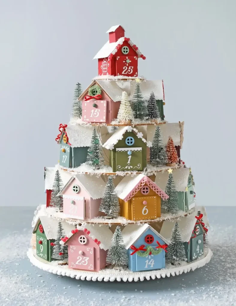 Hand-painted tiered Christmas village advent calendar with glittered rooftops and string lights