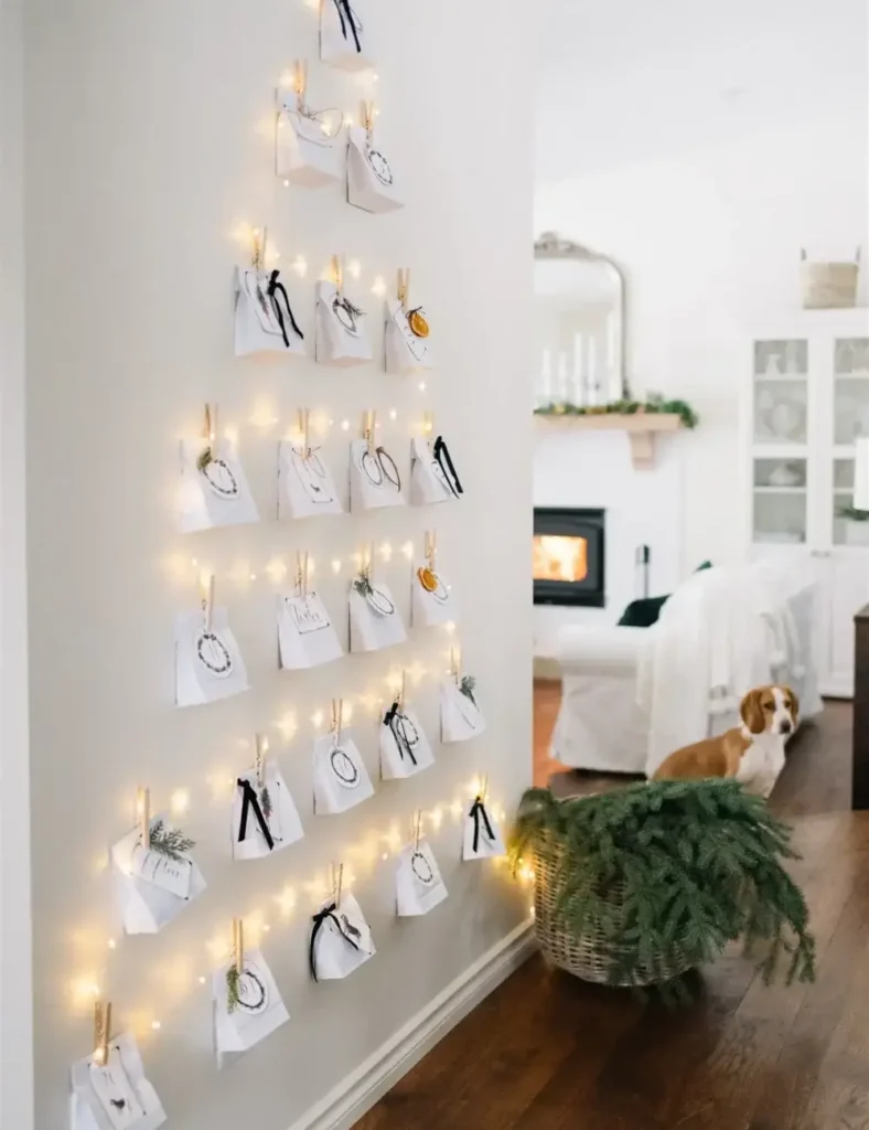 Paper bag advent calendar arranged in a Christmas tree shape on a wall with string lights