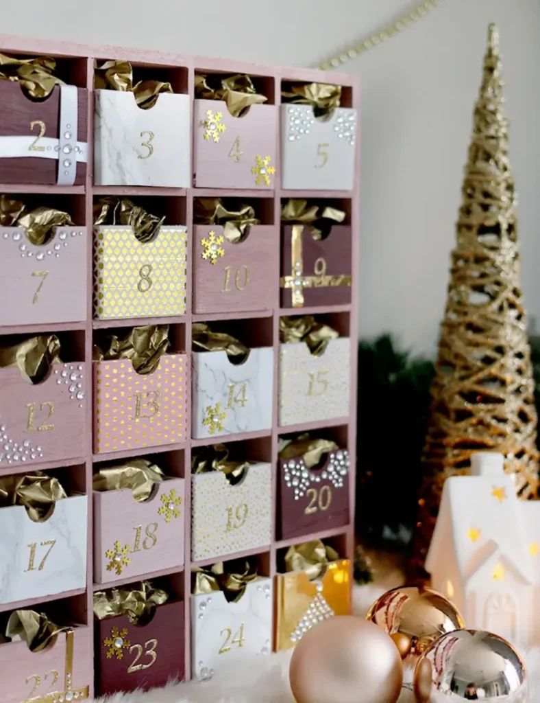 Pink and gold 25-drawer advent calendar cabinet decorated with washi tape and glitter numbers