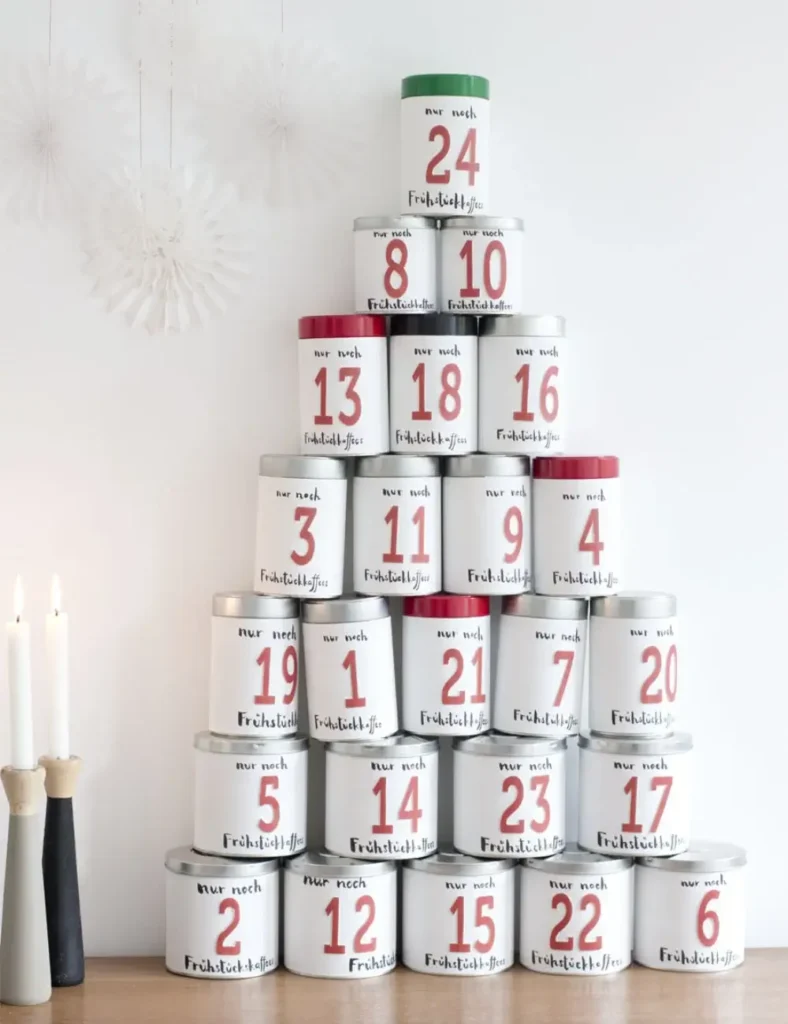 Upcycled coffee tins wrapped in paper and numbered, stacked into a Christmas tree shape