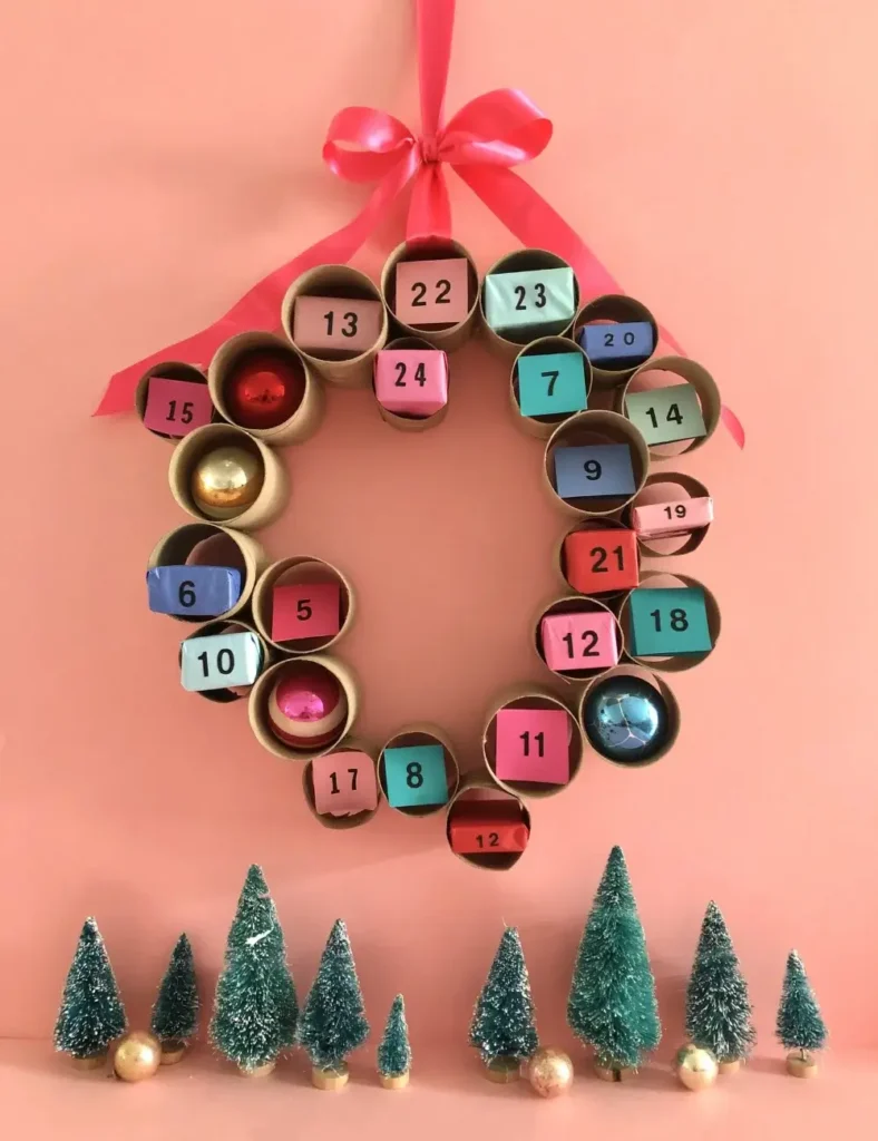 Wreath-shaped advent calendar made from recycled cardboard tubes, each numbered and filled with treats