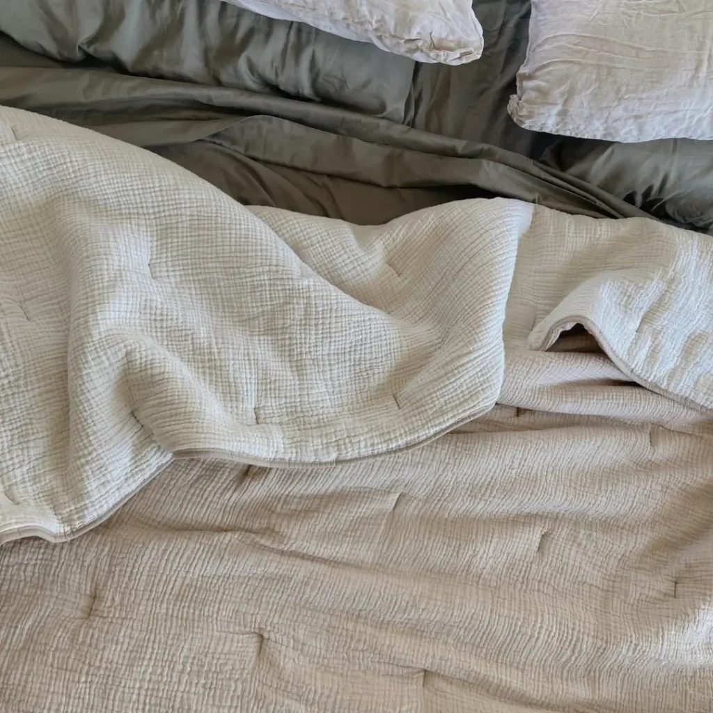top view of a bed unmade. Sheet are neutral colored